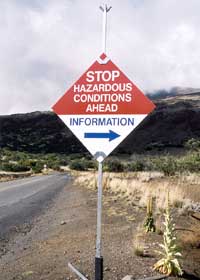 'STOP Hazardous Conditions Ahead' sign, directing travelers to get information at the visitor center